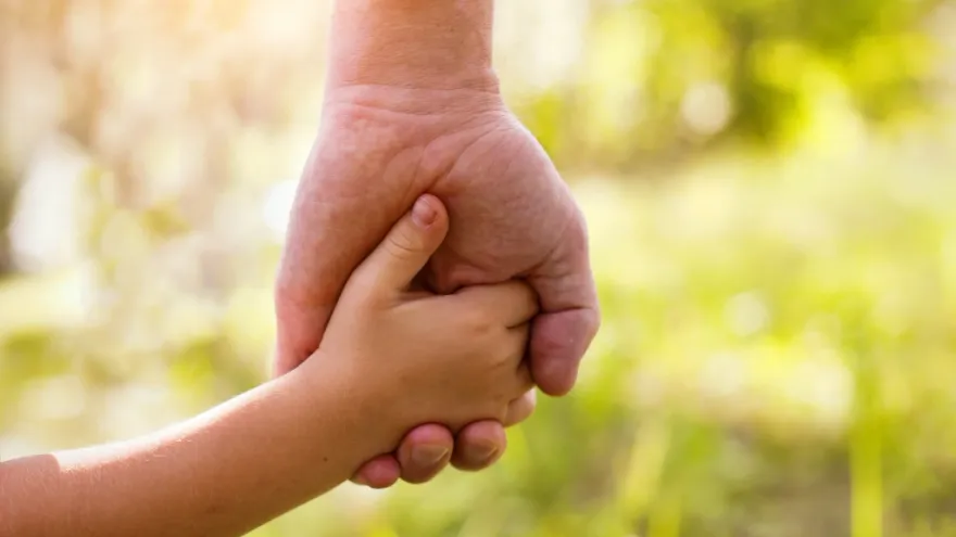 Adulte et enfant se tenant la main - garde d'enfants à Toulouse